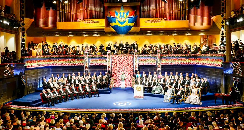 노벨상이 시상식 장면입니다.
관중석, 수상자석, 귀빈석, 그리고 오케스트라가 위치해 있네요, 무대는 중후하면서도 화려한 꽃장식으로 멋지네요