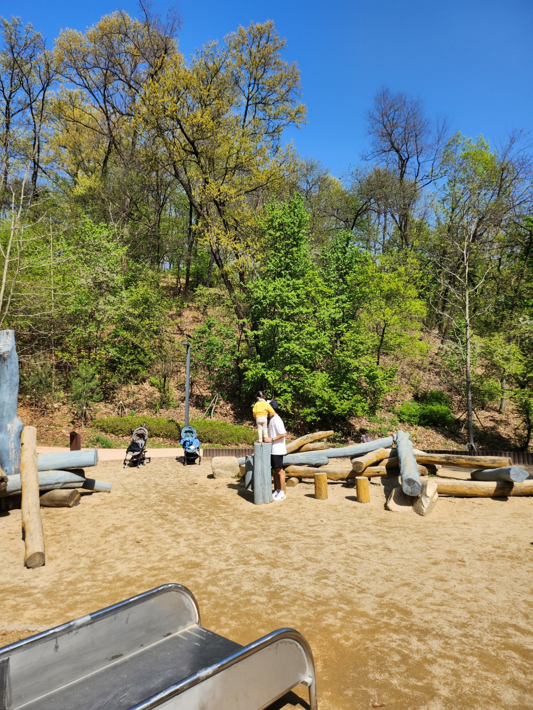 나무 조형물 위에 올라간 아이
