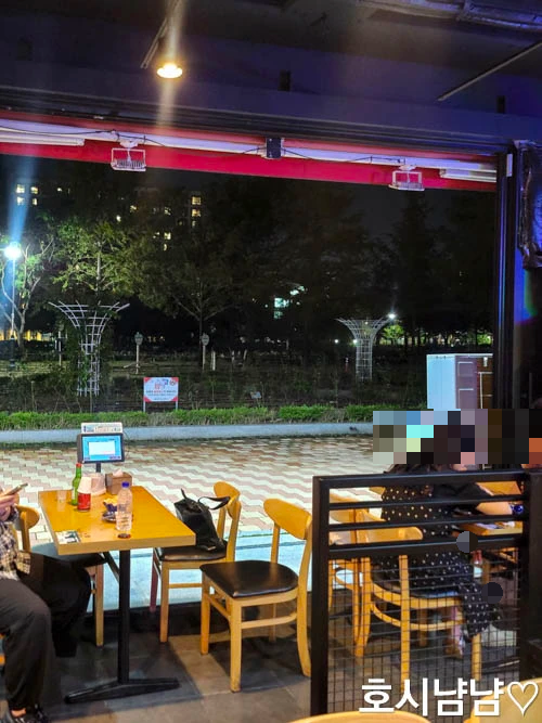 누구나홀딱반한닭 하남풍산점 오픈형 실내 좌석 – 통유리창 밖으로 보이는 공원 뷰, 야외 느낌 나는 테이블 자리