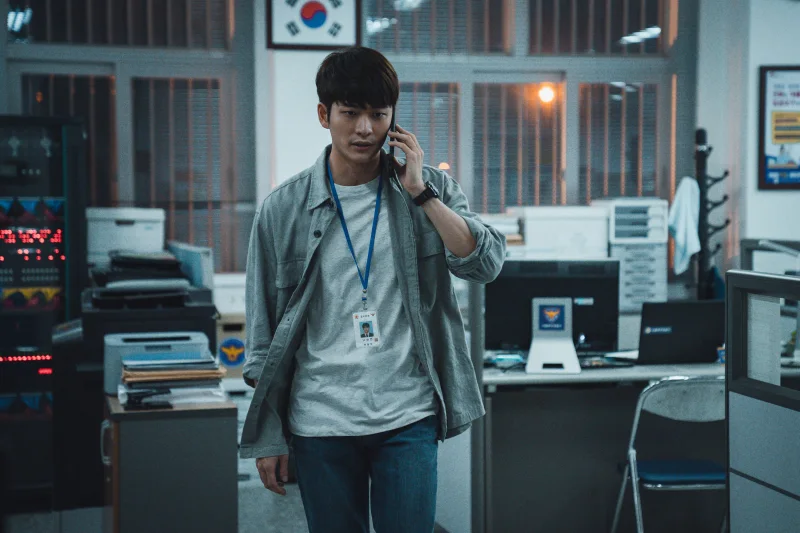 경찰서 실내를 배경으로 청바지에 난방을 입고 전화를 받고 있는 영화 타겟의 나형사