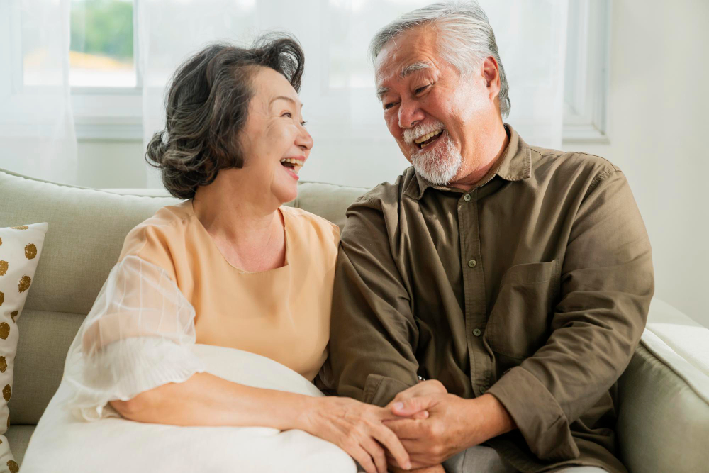 서로 마주 보며 웃고 있는 노년의 부부
