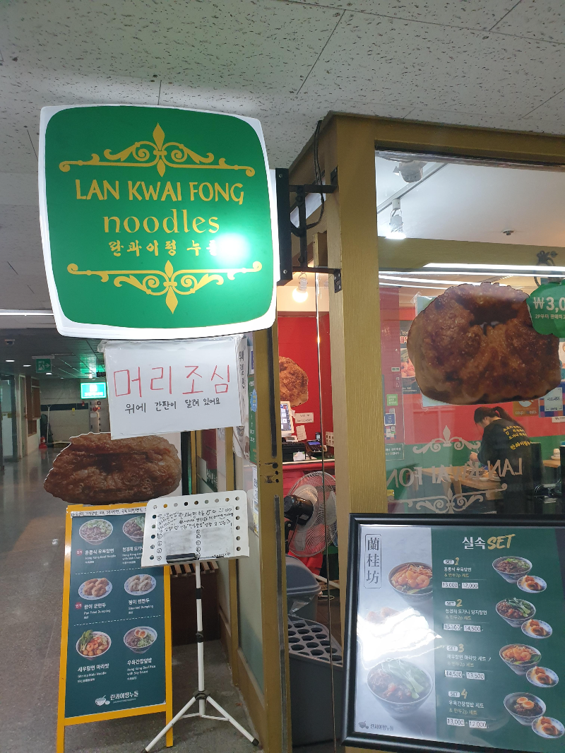 돌출간판 아래 머리 조심이라는 경고 문구가 적혀있다.