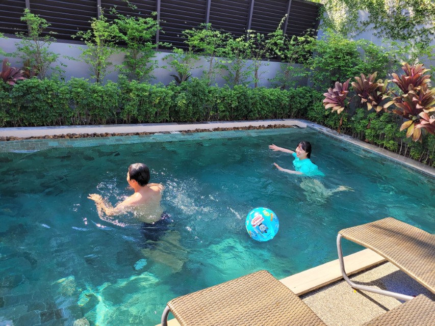 가족이 풀빌라 수영장에서 물놀이하는 모습