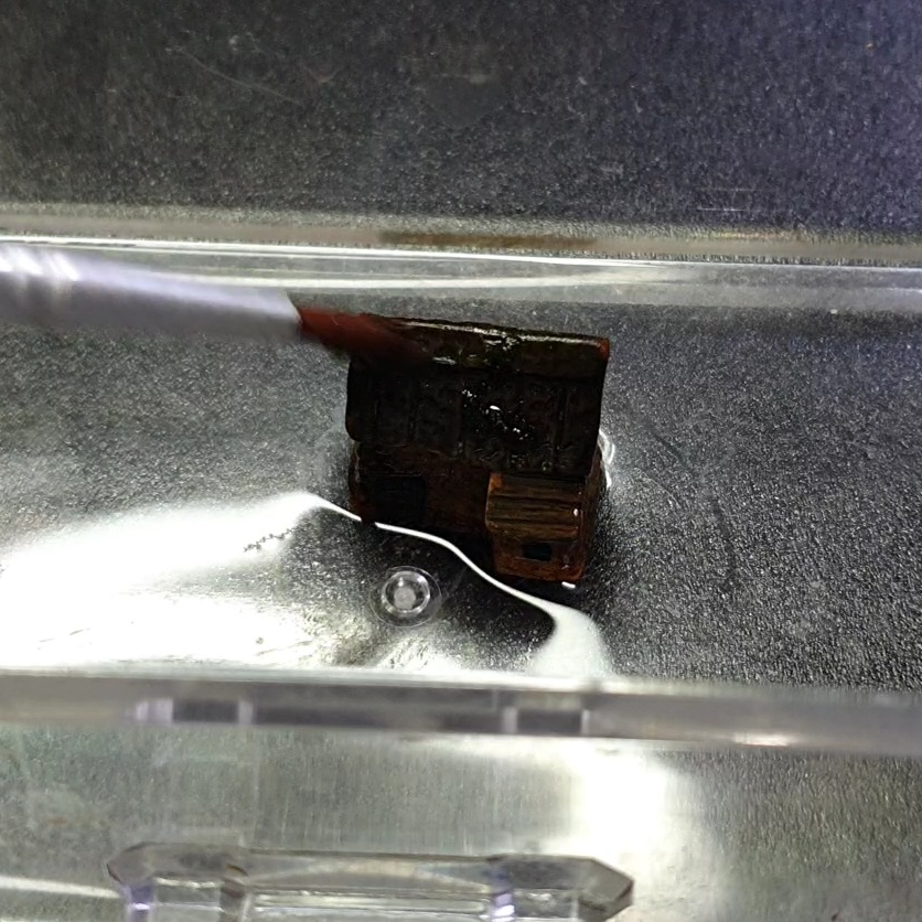 붓으로 이끼를 피규어에 붙이는 모습