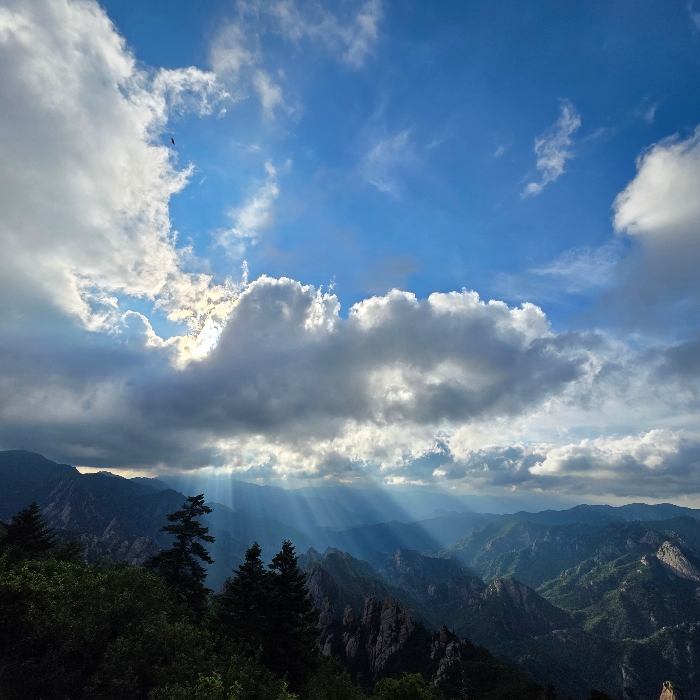August sky filled with clouds, sunlight shining from behind, a nostalgic view.