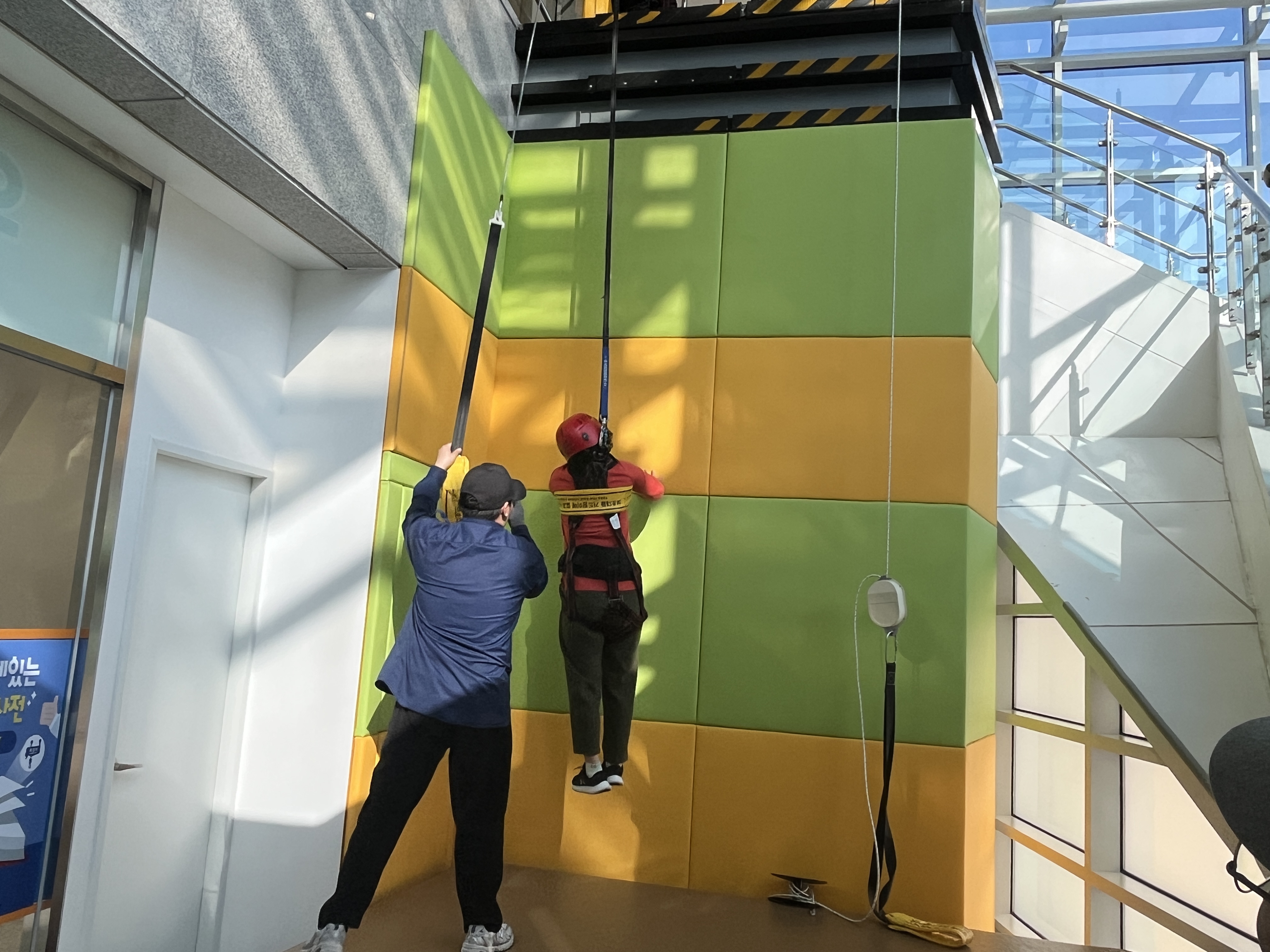 2층높이에서 완강기를 사용하여 내려오고있다.