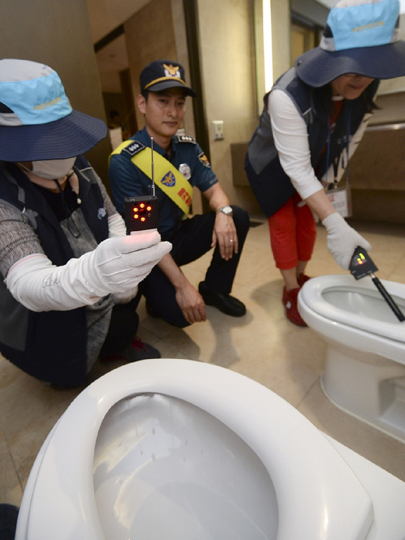 경찰이 화장실 불법촬영 카메라를 탐지하고 있다. [사진=뉴시스]