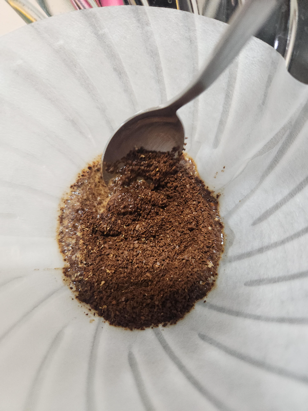 스푼으로 커피 파우더에 물을 적시는 모습