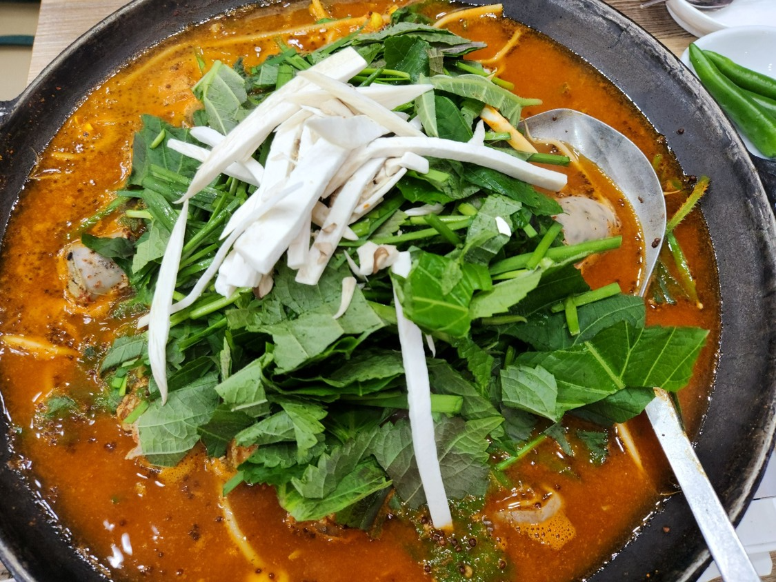 순대 전골 위에 야채와 버섯이 가득 올려져 있다