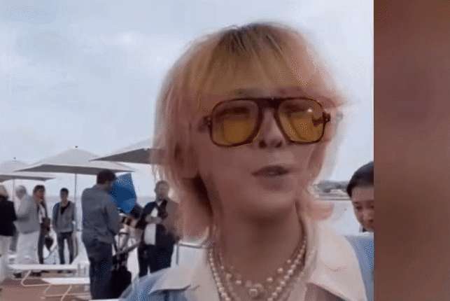 노란 선글라스를 착용한 가수 권지용의 건글거리며 외국에서 인터뷰하는 모습