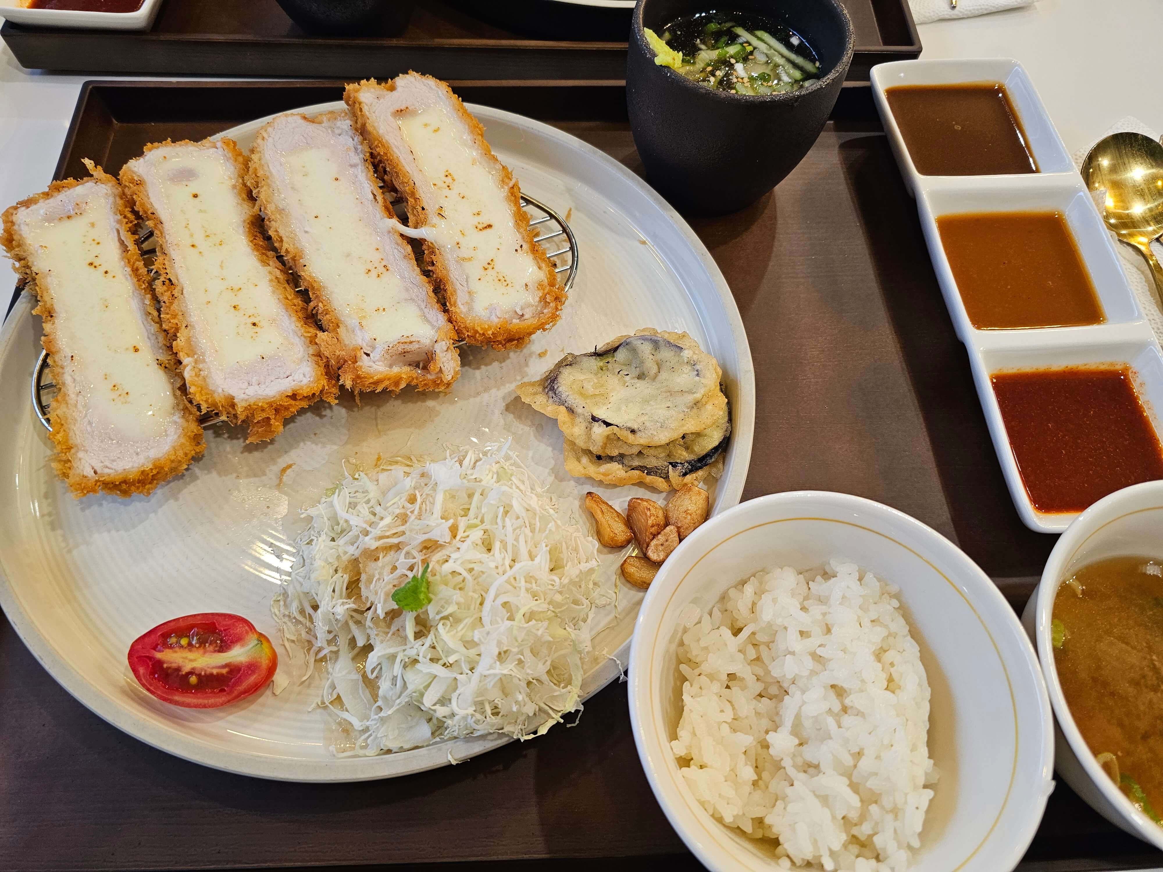 치즈 돈까스의 전체 상차림 장면입니다.