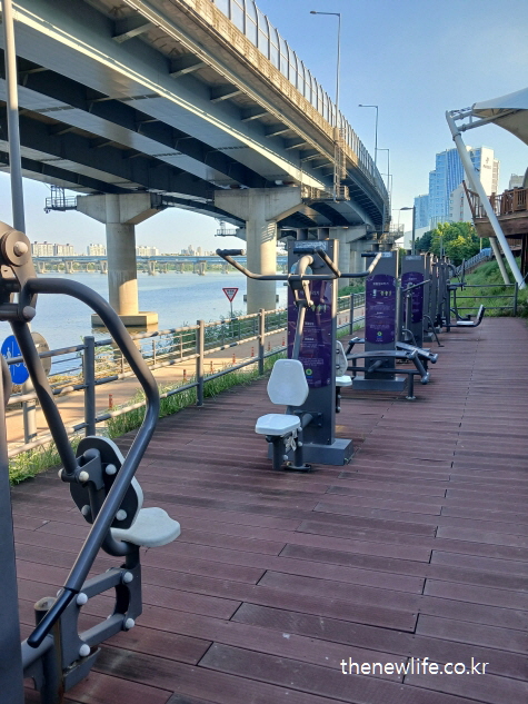 한강변 데크 위에 설치된 고급형 실외 운동기구 &ndash; 뱃살 빼는 운동을 위한 지속 가능한 하체 운동 환경
