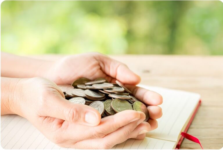 동전을 가득 두 손에 모아 놓은 모습