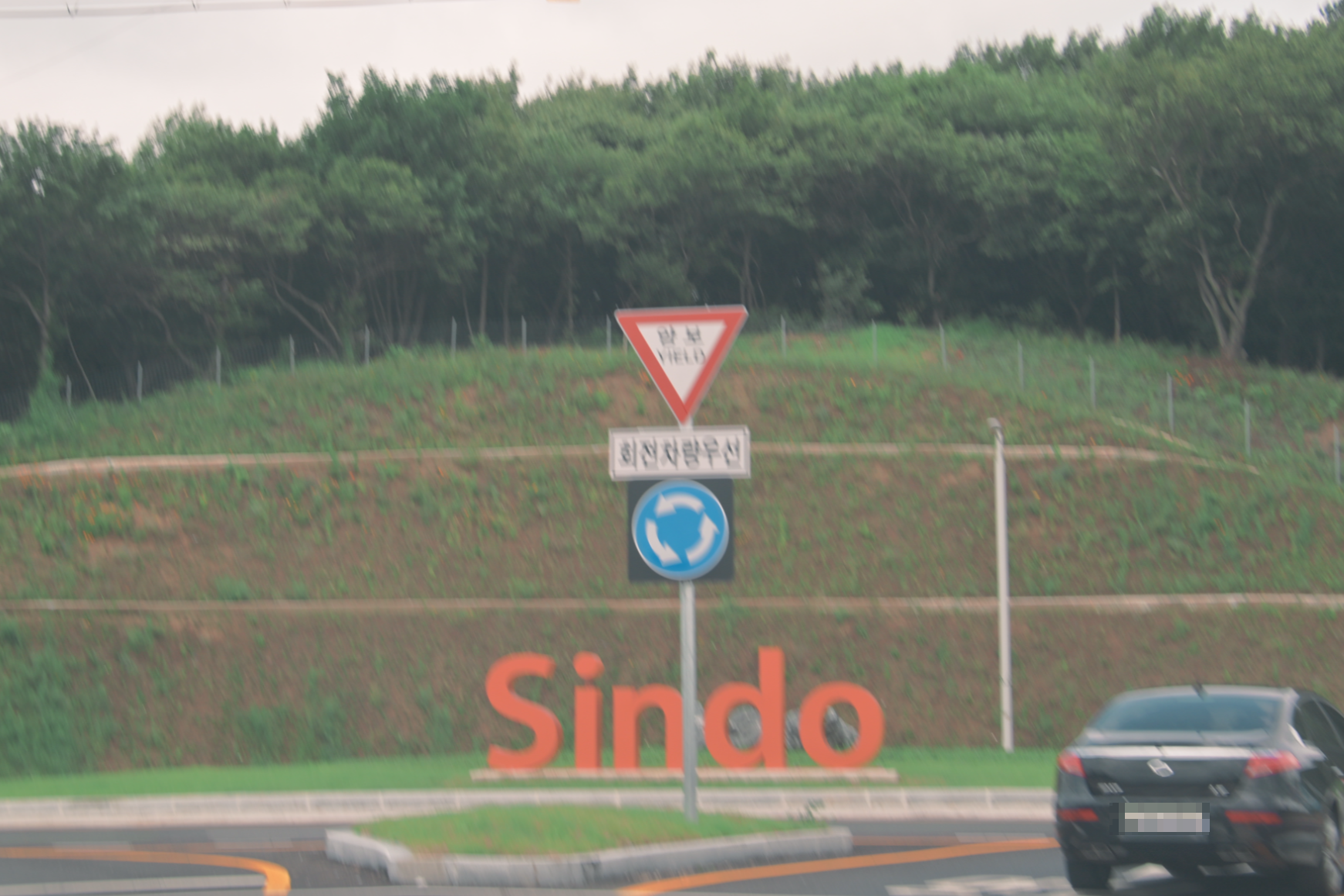 sindo라고 쓰인 구조물이 놓여진 교차로