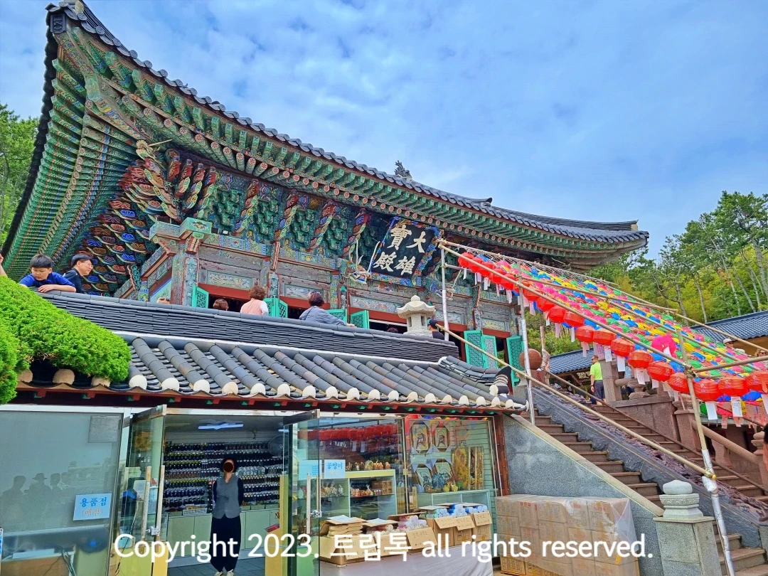 기와지붕의 절과 그 아래로 연등이 달려있고 아랫층에는 기념풍을 파는 가게가 있다