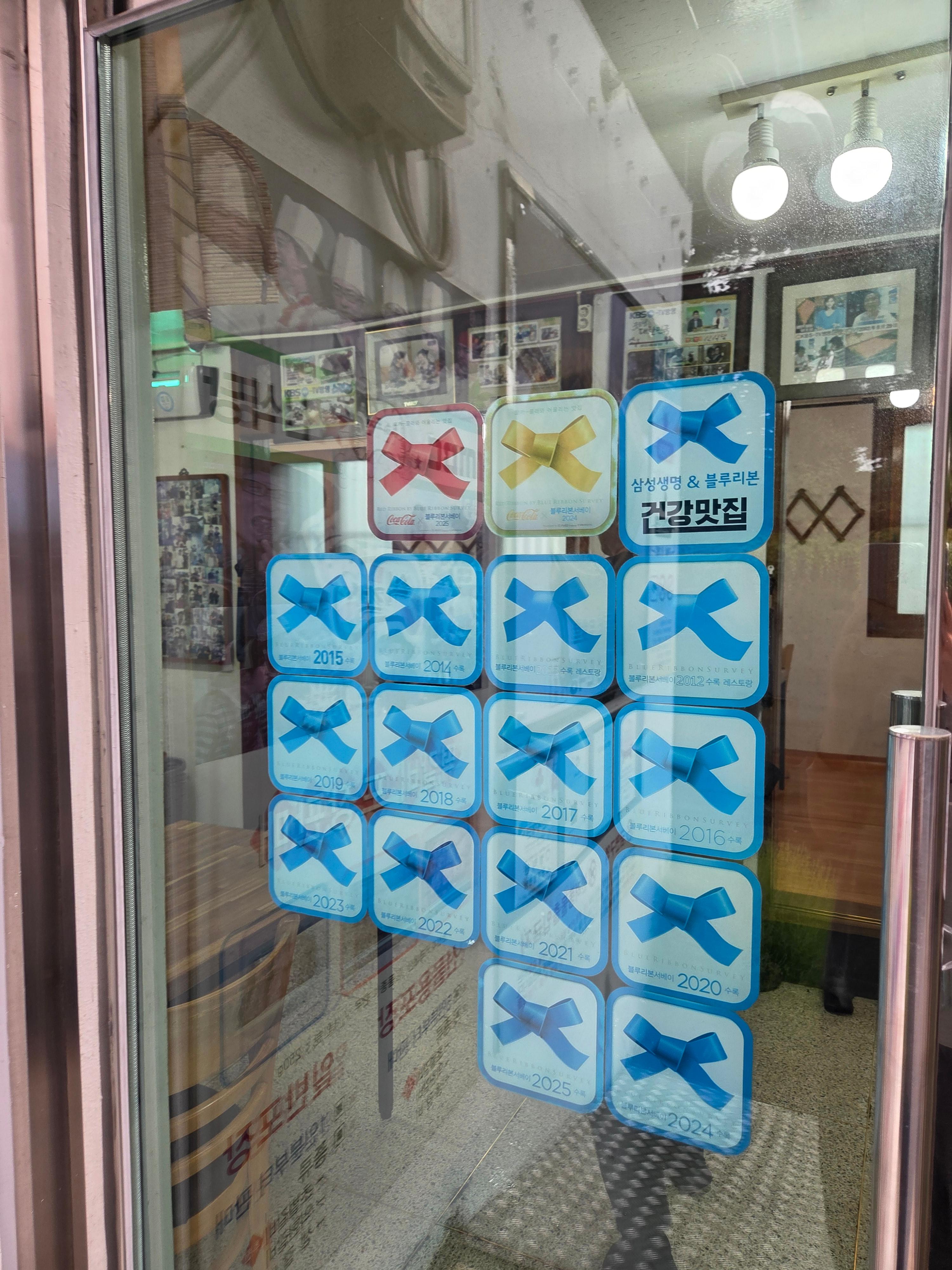 신식당 입구 유리문에 부착된 블루리본 인증 스티커