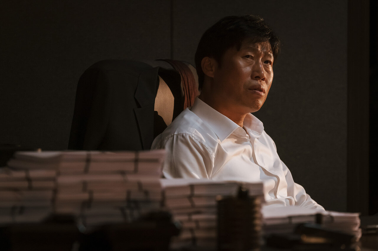 야망 가득한 검사 구관희가 책상에 앉아있는 모습