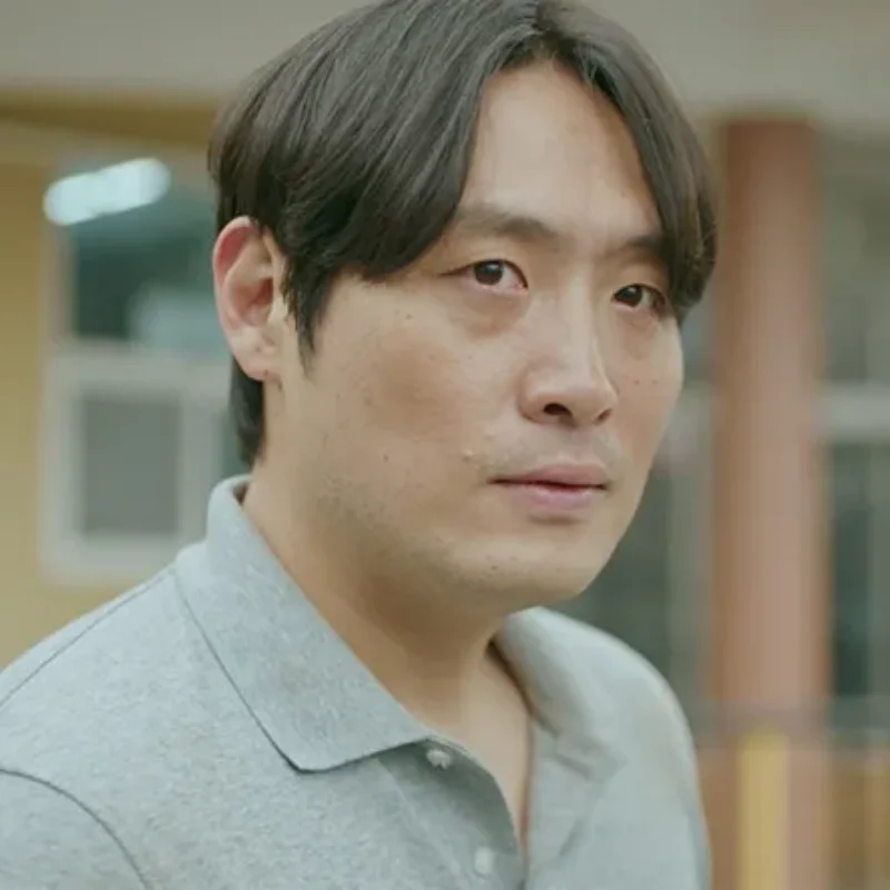 어느 실내를 배경으로 회색티를 입고 누군가를 무섭게 노려보고 있는 소용없어 거짓말의 최엄호