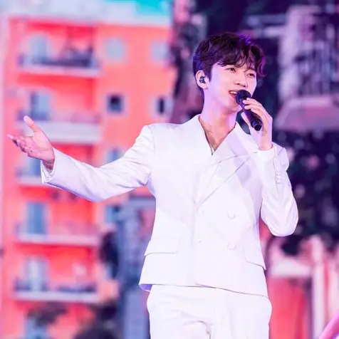 임영웅- 흰색쟈켓을 입고 왼손으로 마이크를 잡고 노래하고 있는 임영웅