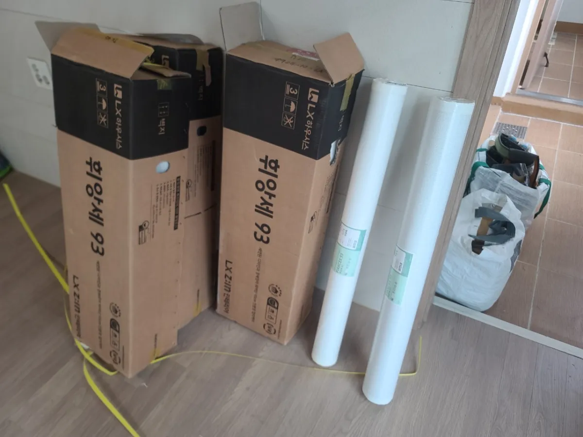 벽에-휘앙세모델의-벽지들이-세워져-있다