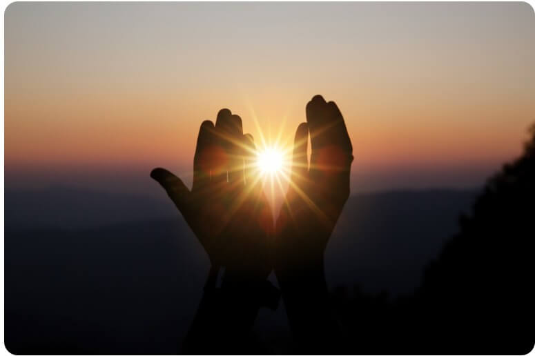 태양을 두 손을 모아 일부를 가린 모습