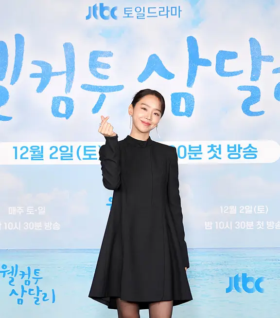 파란색 바다배경 웰컴투삼달리 글자 - 앞 신혜선이 검은 미니 원피스를 입고 포즈를 취하고 있는 모습