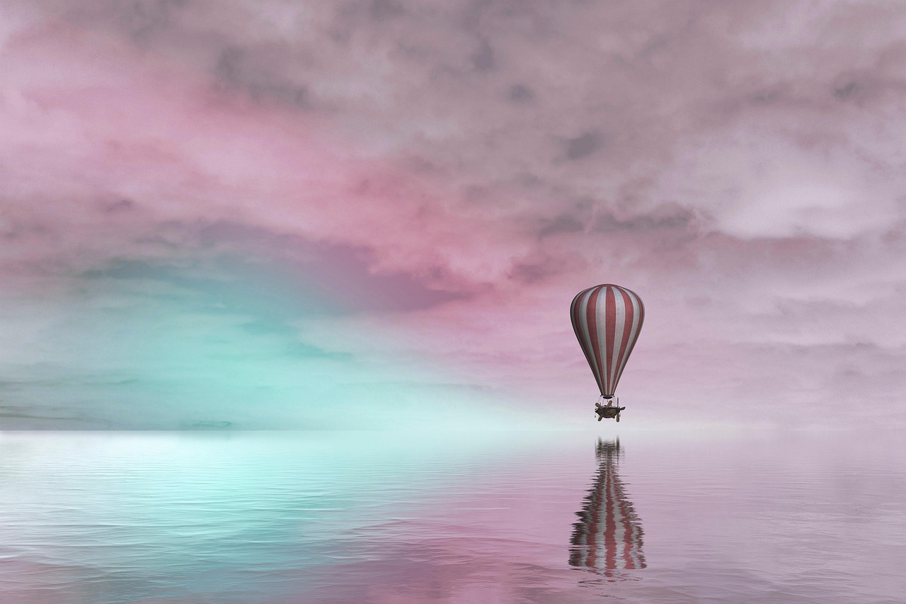 몽환적인 핑크빛 하늘에 자유롭게 비행하고 있는 열기구