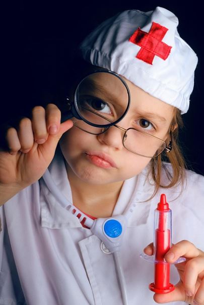 꼬마의사 한쪽손에 돋보기를 들고 한쪽손엔 장난감 주사기를 들고있는 사진