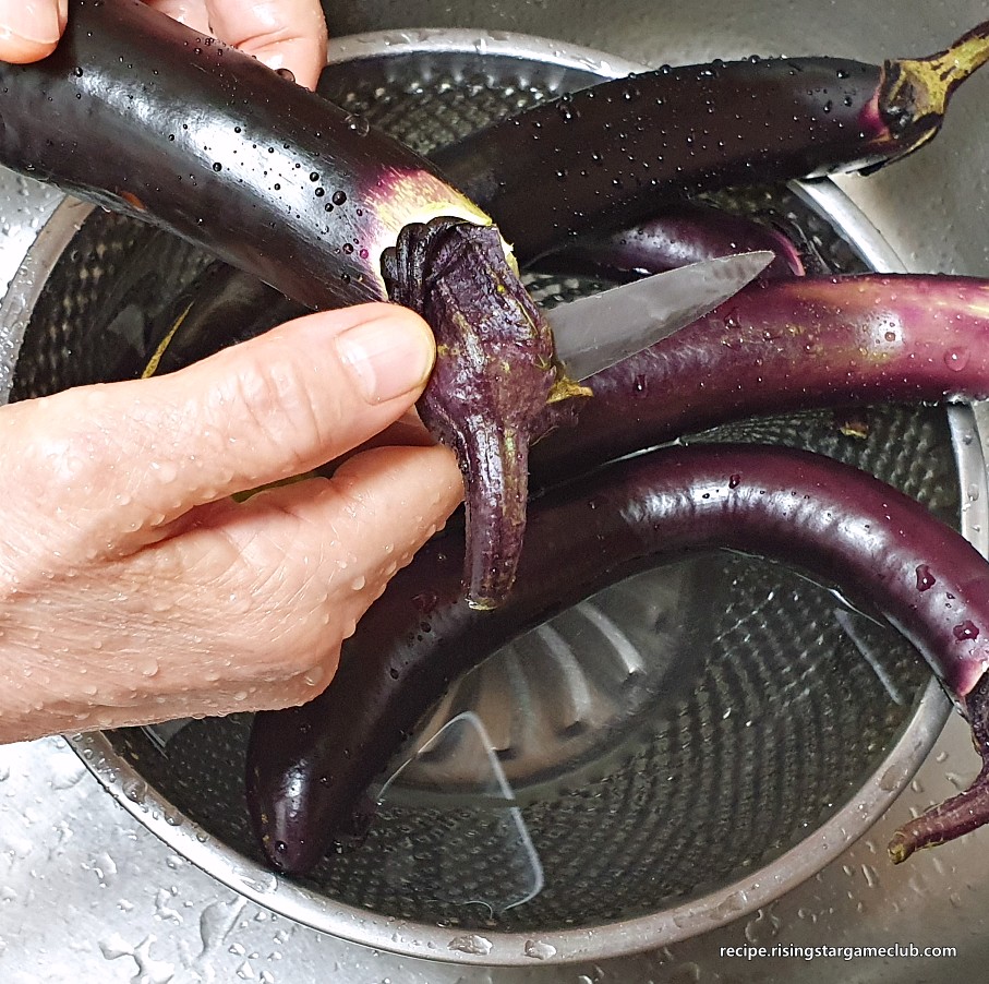 가지 볶음에 들어갈 가지의 꼭지 부분을 과도로 제거하는 사진