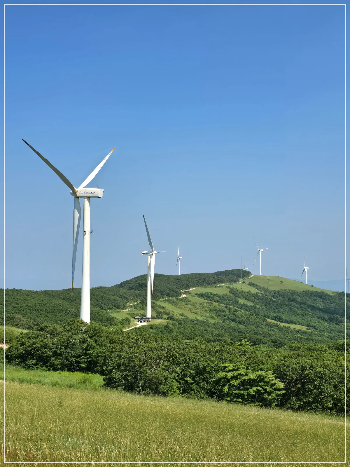 여러개의풍차_산정상_초록나무_파란하늘