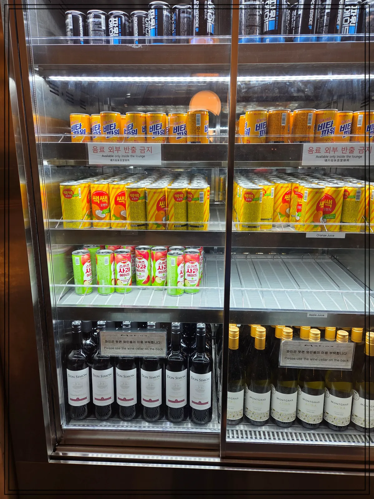 음료와-와인이-정리된-유리-냉장고-에너지음료-과일주스-포도주-화이트와인이-층별로-진열되어-있고-반출-금지-표시가-붙어-있음