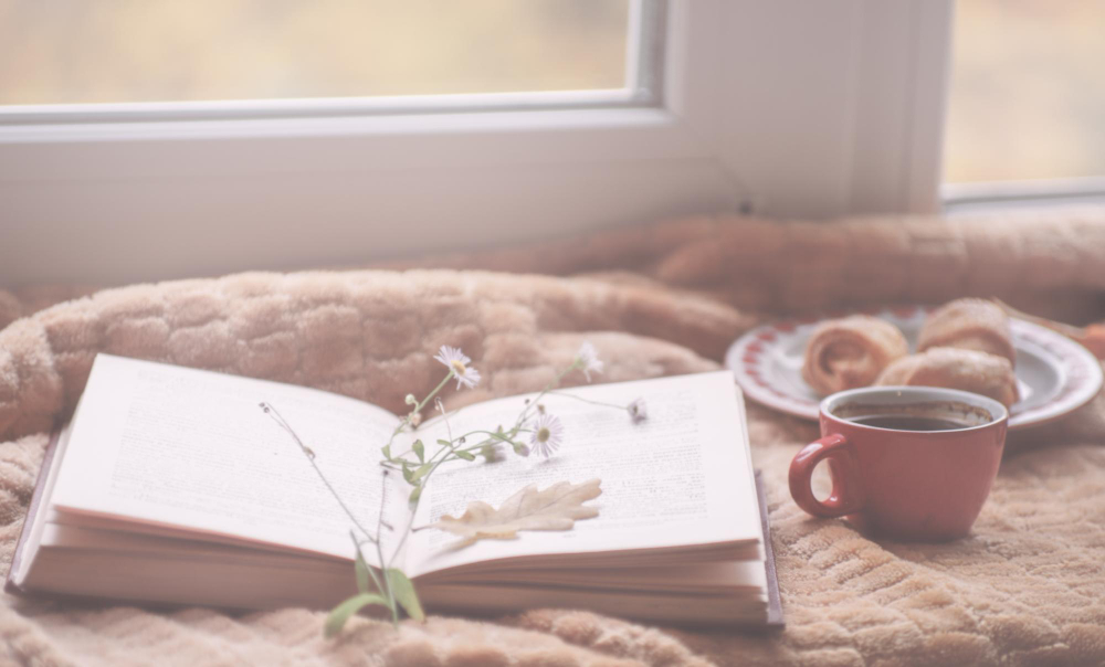 따뜻한 공간에서 커피를 마시며 책을 읽는 모습