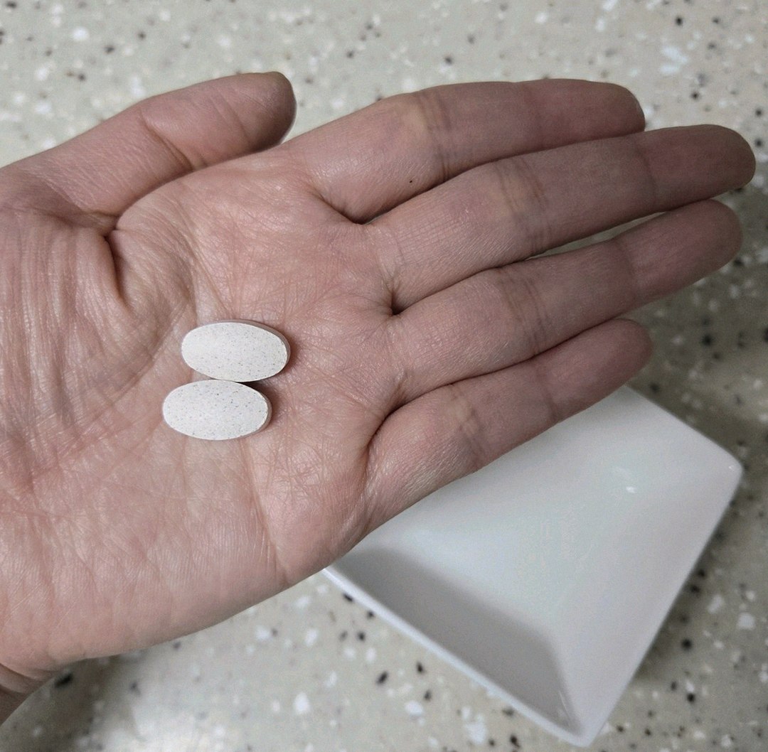 Korean Asian man in his late 30s taking supplement in morning routine at home