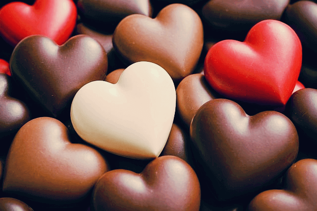 하트 모양의 초콜릿들이 가득하다. 빨간색 초콜릿, 고동색 초콜릿, 하얀색초콜릿이다.