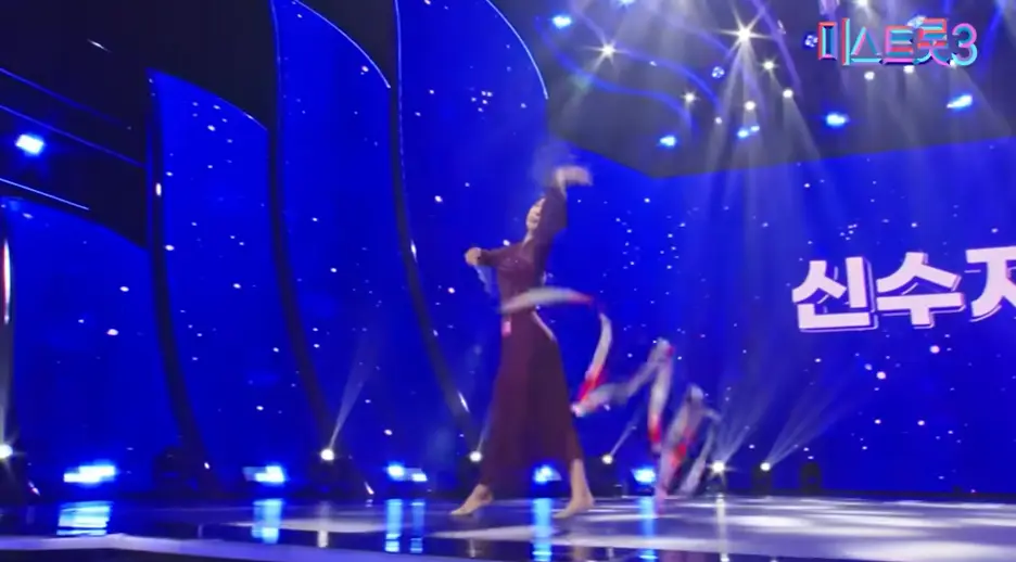 미스트롯3- 불은색 망사드레스를 입고 오른손으로 리본끈으로 체조를 하고 있는 신수지