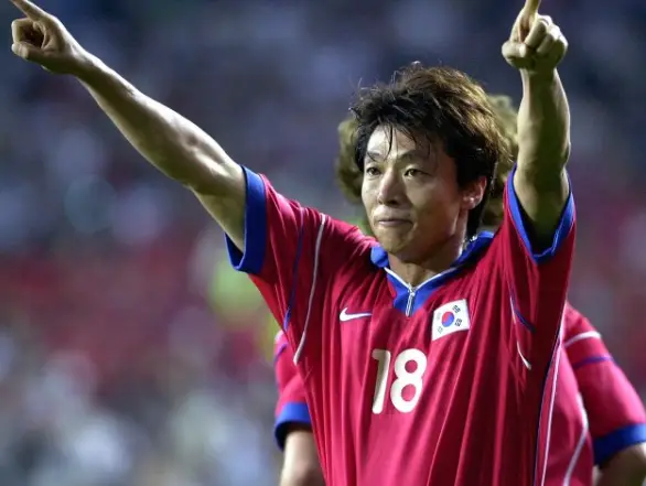 황선홍- 붉은반팔상의 국가대표 유니폼을 입은 황선홍이 입을 꾹 다물고 두팔을 높이 올린 모습