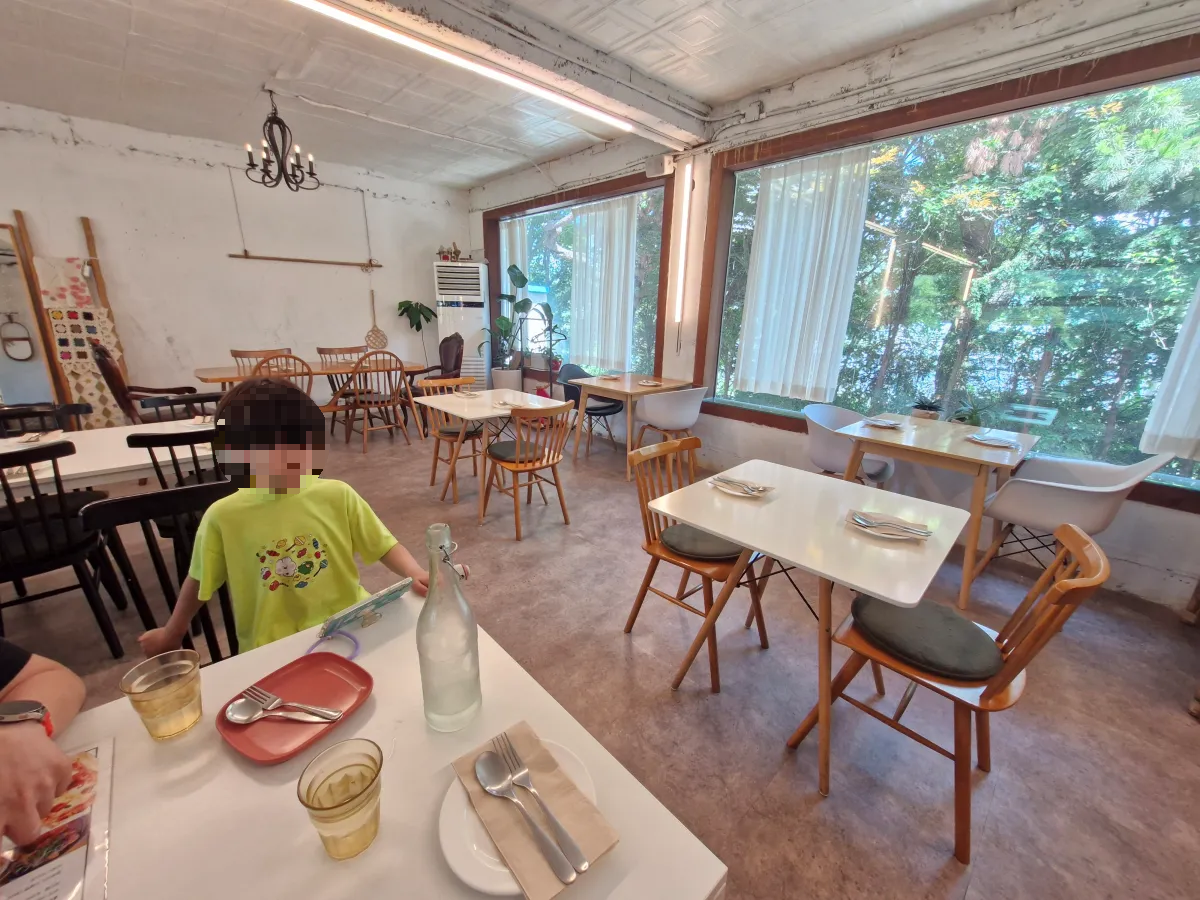 초록색-옷을-입은-아이가-의자에-앉아-있다