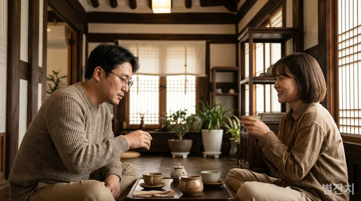 조용한 한국 전통 찻집에서 멘토와 멘티가 차를 마시며 대화하는 모습
