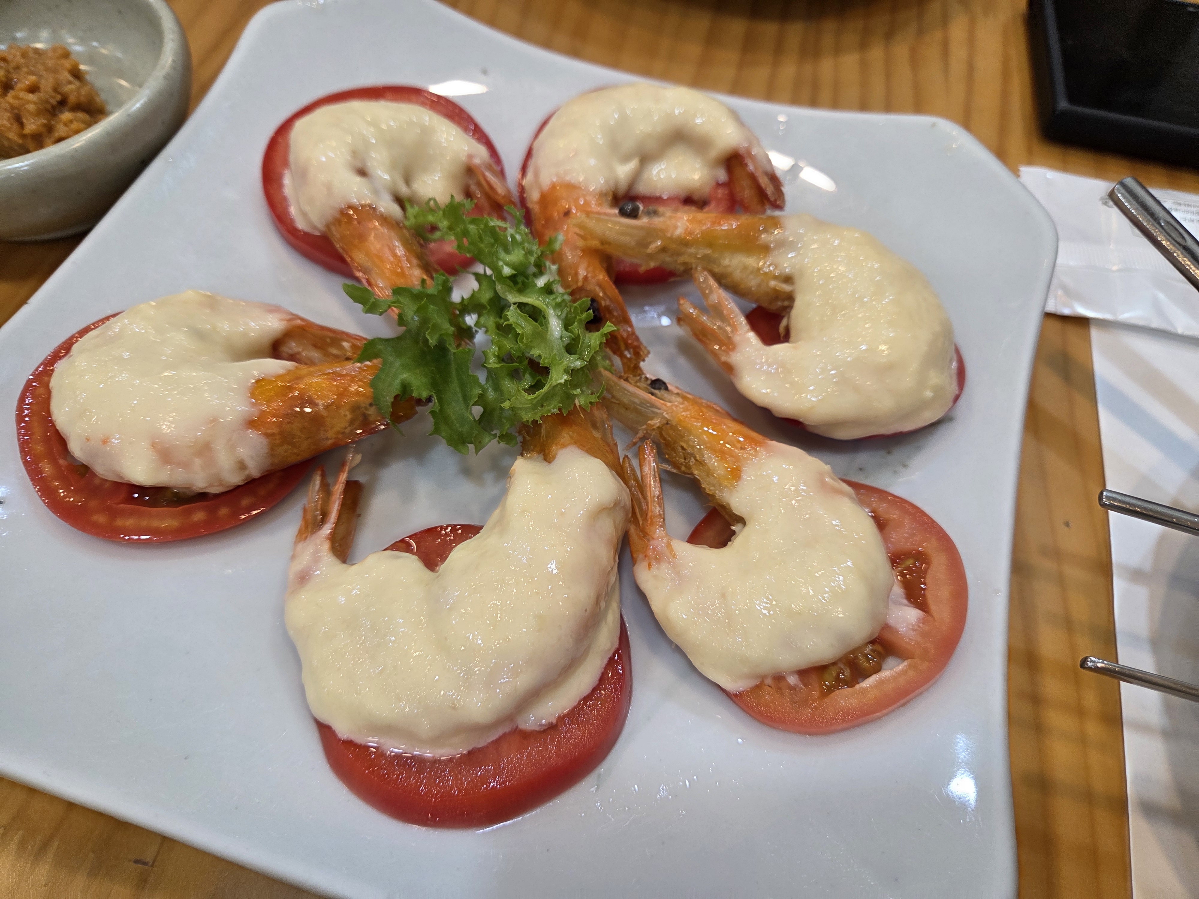 황금소나무 한정식 새우 요리 토마토 위에 새우와 하얀 소스가 올라간 메뉴