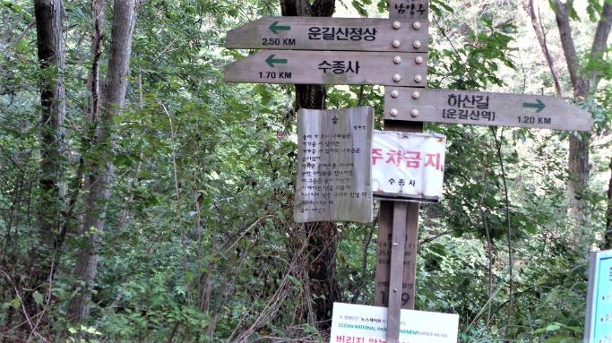 등산 안내판 옆에 이정표, 빛바랜 회색 나무판, 수종사 왼쪽으로 1.7km, 그리고 붙어 있는 주차금지 경고문,