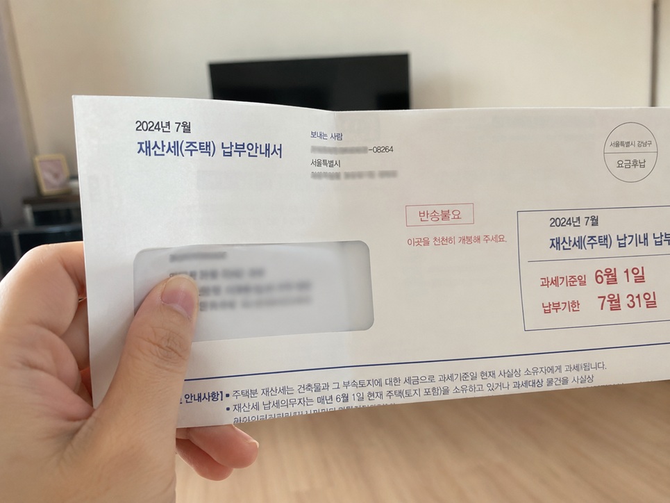 실제 재산세 고지서를 손에 들고 확인하는 모습으로 개인정보는 가린 상태