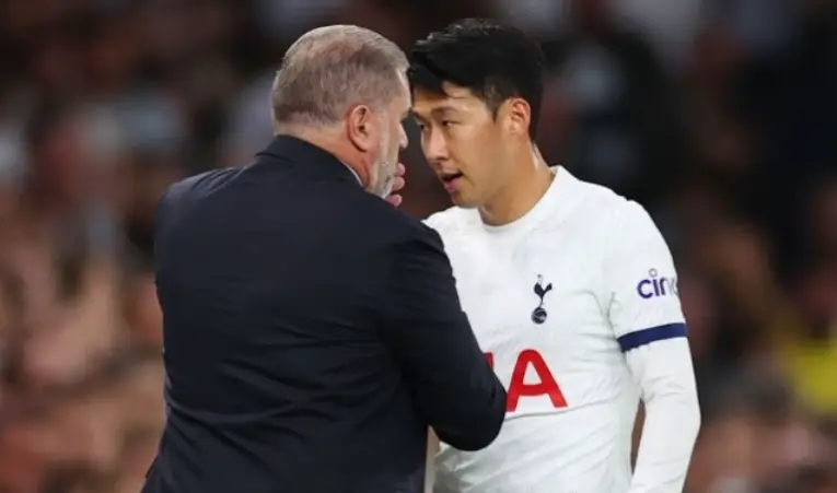 손흥민- 검은 양복을 입은 토트넘 감독이 흰 유니폼을 입은 손흥민과 진지하게 이야기 하는 모습