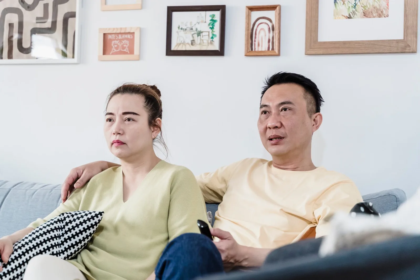 아늑한 거실에서 편안한 소파에 앉아 함께 여유로운 시간을 즐기는 커플.