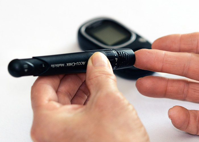 혈당측정기로 혈당을 측정하고 있다