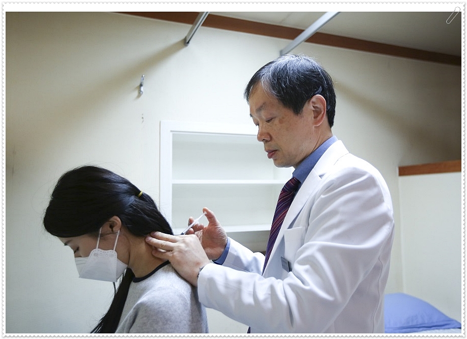 환자의 목 뒤에 약침을 놓고 있는 한의사와 침을 맞고 있는 여성 환자의 모습