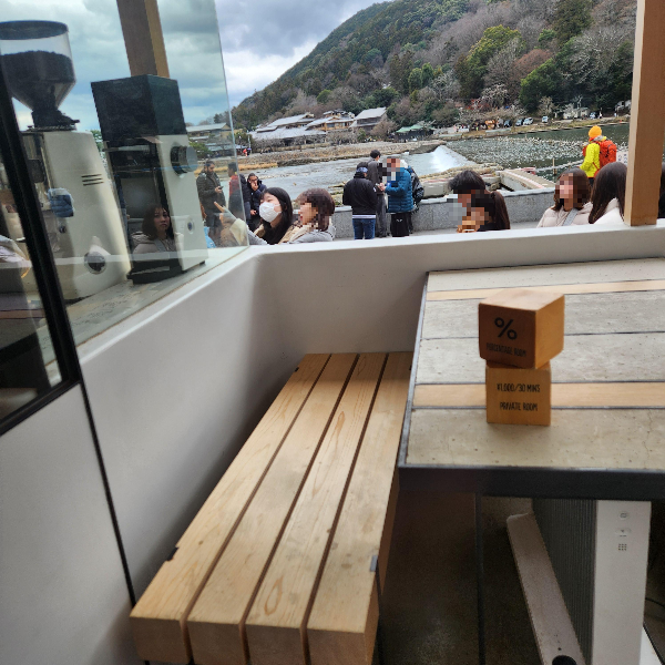 강이 보이는 좌석, 우드로 된 테이블과 의자가 있다.