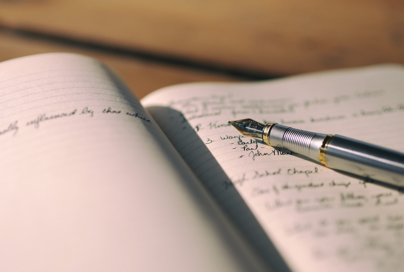 writing on a notebook with a pen