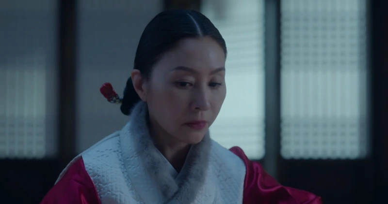 한옥을 배경으로 빨간 한복에 쪽두리를 한 김씨 부인