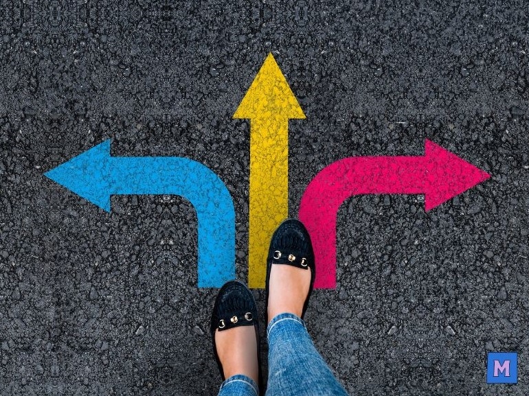 아스팔트 바닥에 그려진 세 개의 색깔 화살표(파란색 왼쪽, 노란색 위쪽, 분홍색 오른쪽) 앞에 서 있는 사람의 발 via canva