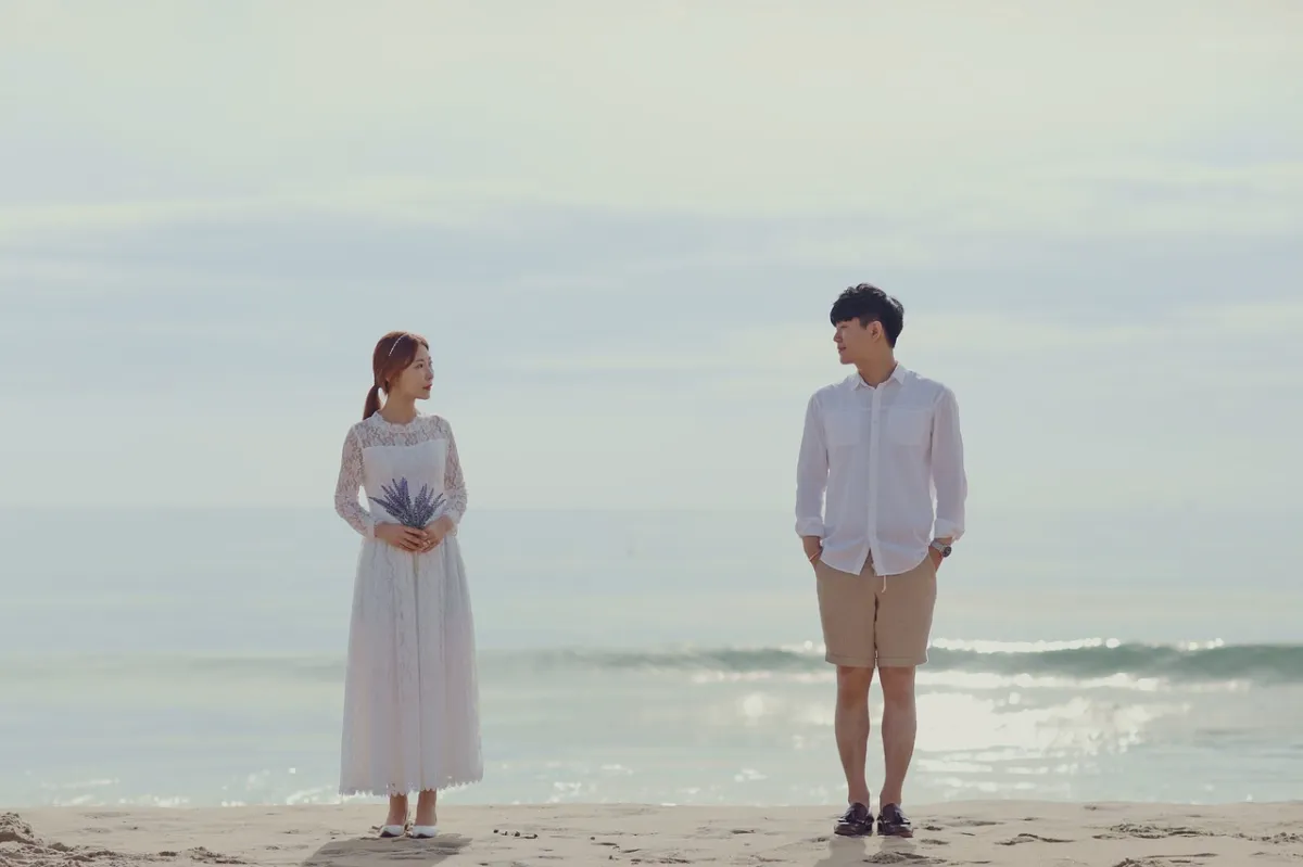해변가-앞에-마주보고-서있는-신혼부부
